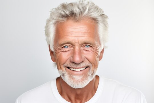 Portrait of happy senior man looking at camera and smiling, on grey background