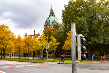 Bicycle traffic light at the intersection of streets. Bicycle infrastructure in Germany. The new town hall in Hanover in the background, autumn trees