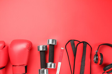 Flat lay composition with dumbbells on red background, space for text