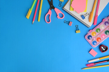 Flat lay composition with notebook and other school stationery on light blue background, space for text. Back to school