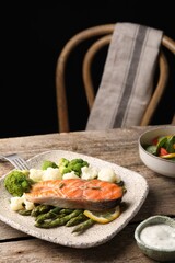 Healthy meal. Tasty grilled salmon with vegetables served on wooden table