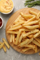 Delicious french fries served with sauces on grey marble table, flat lay