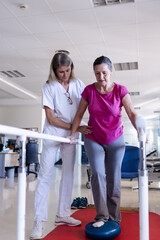 A female physiotherapist and her female patient are doing rehabilitation in the hospital.