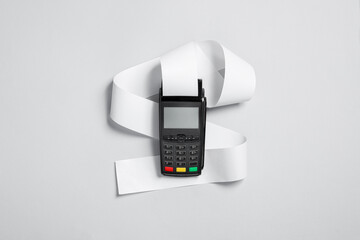 Payment terminal with thermal paper for receipt on light grey background, top view