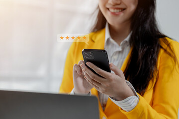 A young woman is rating the service she received on her smartphone, The customer gave five stars to the product she received with complete satisfaction.