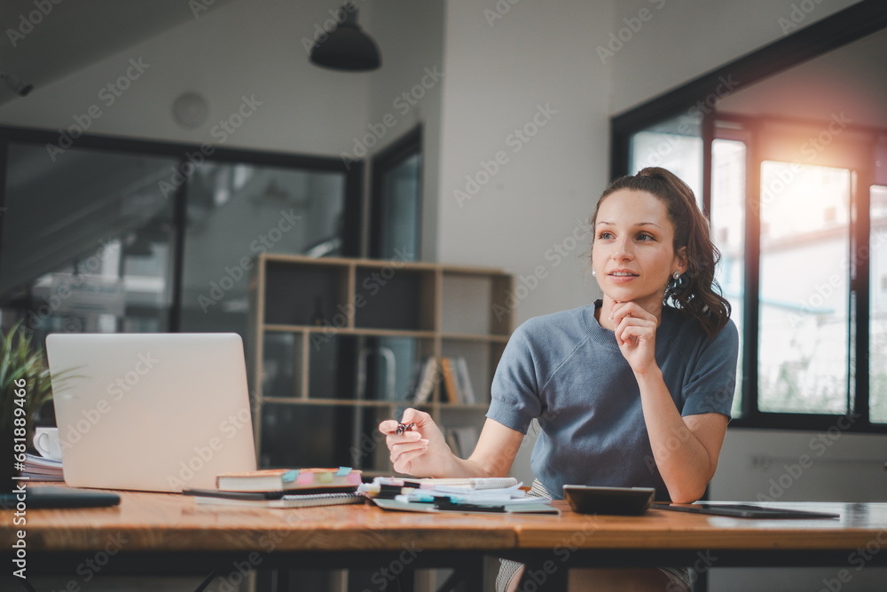 Poster smiling young woman using calculator and laptop computer to calculate financial report, working at o