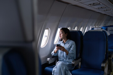 Asian people female person onboard, airplane window, using mobile while on the plane