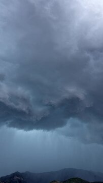Vertical Timelapse of dramatic storm rolling over the mountains in Utah over Nebo during summer monsoon.