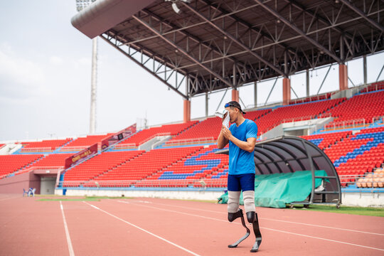 Asian para-athlete with prosthetic blades taking a break after exercise.