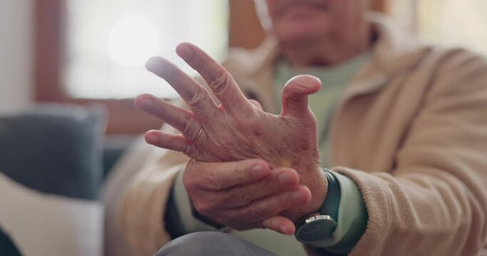 Closeup, hands and senior man with wrist pain, injury and inflammation with bruise, home and broken. Zoom, pensioner and elderly guy on a couch, fingers with ache and arthritis with sprain and strain