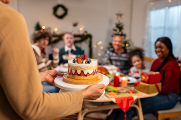 Multi-ethnic big family celebrating Christmas party together in house.  - obrazy, fototapety, plakaty