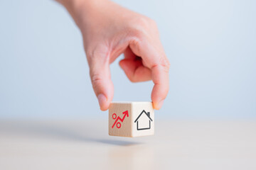 Hand holds wooden cube with house and percentage icons. Real estate investment, property asset...