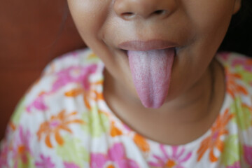 child shows his tongue closeup 