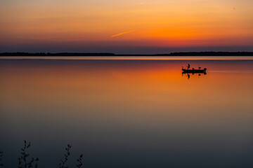 Fishing Boat on Colorful Reflective Lake in Evening Twilight