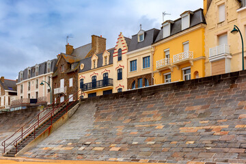 Fototapeta na wymiar High stone embankment and beach at low tide, in beautiful Saint-Malo, Brittany, France