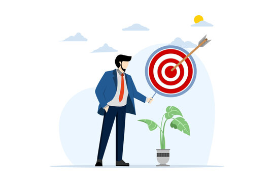 Dartboard inside a magnifying glass for business goal target. The red arrow hits the center of the dartboard. Business success, investment goals, challenges opportunities, goal strategies.