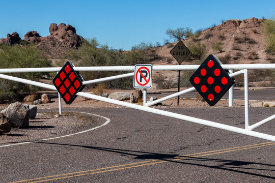 No parking sign on the road with white gate in desert landscape environment