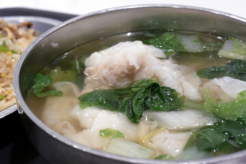 One side of fried rice and seafood dumpling soup on table inside restaurant