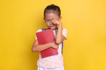 Asian little girl rubbing her eyes feeling tired after school