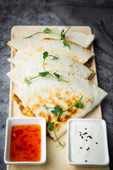 crispy flatbreads stuffed with meat, herbs, lime and two sauces, side view