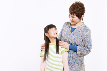 孫の肩に手を乗せる祖母