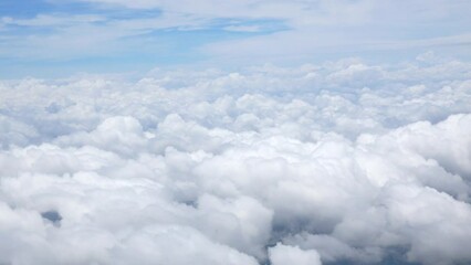 blue sky with white fluffy clouds from airplane flight fly over the clouds in a sunny day with cloud moving in the atmosphere in hot weather summer time.