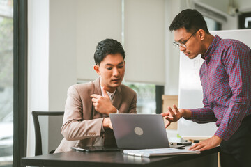 Two professionals in meeting, one presenting "Business, Plan, Success" on whiteboard, another observing and holding a clipboard. Asian businessman, Colleagues, Middle-age