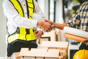 Two men engineer housing team meeting, one in safety vest holding color swatches, discussing plans, engineers architects talking house design color. Choosing paint for exterior and interior walls