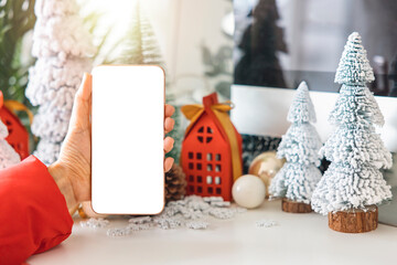 Gentle hands cradle a smartphone with a white screen mock up  by festive scene a beautiful...