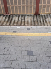 
It is a sidewalk block road with a fence.