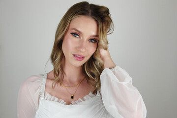 Captivating Blue Eyes and Brunette Beauty: Allure in White Shirt with Black and Gold Necklace
