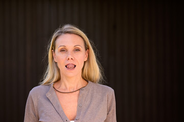 Portrait of an attractive blonde woman sticking out her tongue