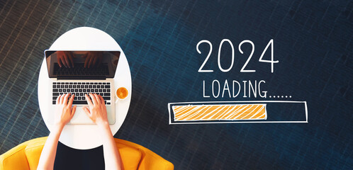 Loading new year 2024 with person using a laptop on a white table