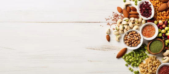 Poster In the top view of a food-filled plate, a healthy array of ingredients, including walnuts, almonds, peanuts, raisins, cashews, hazelnuts, and pistachios, are scattered amidst a variety of seeds and © 2rogan