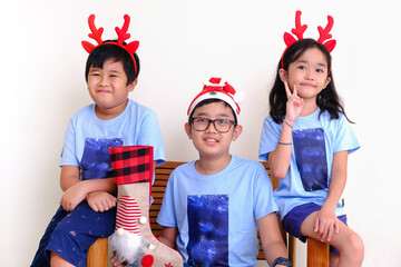 Three Asian beautiful children posing for Christmas celebration with their reindeer horns on their...