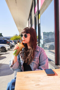 Friends drink boba at outdoor table 