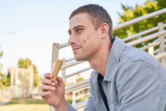 Couple eats yogurt and protein bar on bleachers outside