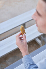 Couple eats yogurt and protein bar on bleachers outside