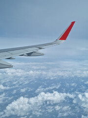 Fototapeta na wymiar Airplane wing through the clouds in the sky.