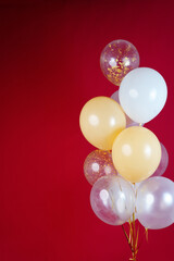 A bunch of light balloons on a red background. Vertical Photo Space for Text