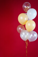 A bunch of light balloons on a red background. Vertical Photo Space for Text