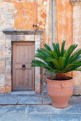 Exterior of an ancient building with fresh flower in a clay pot, Crete, Grece