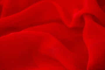 Red chiffon or silk material. Satin fabric close up background and texture with place for text....