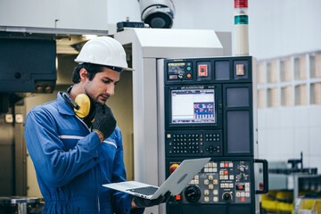 Engineer foreman thinking and working with computer laptop connecting to controlling machine at the manufacturing factory. Technician maintenance system or developing machinery