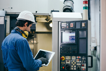 Engineer foreman thinking and working with computer laptop connecting to controlling machine at the manufacturing factory. Technician maintenance system or developing machinery