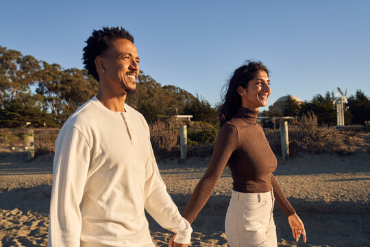 Interracial Couple at The Beach Together in Love Enjoying Each Other Company 
