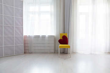Fototapeta premium One yellow chair in white room interior with window