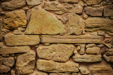 Close-up of Textured Stone Wall with Brickwork and Wood Detail. Textured stone wall with wood and brickwork patterns.