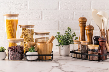 Stylish convenient storage of food and spices on the kitchen countertop with potted indoor plants....