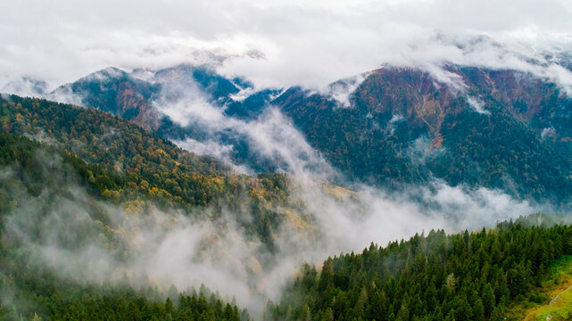 Foggy mountain landscape. Mountains covered with fog and clouds. Misty forest landscape.